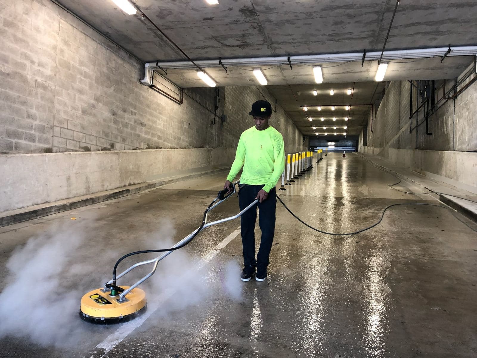 Crew pressure washing a parking garage floor — Finesse Cleaning, South Florida