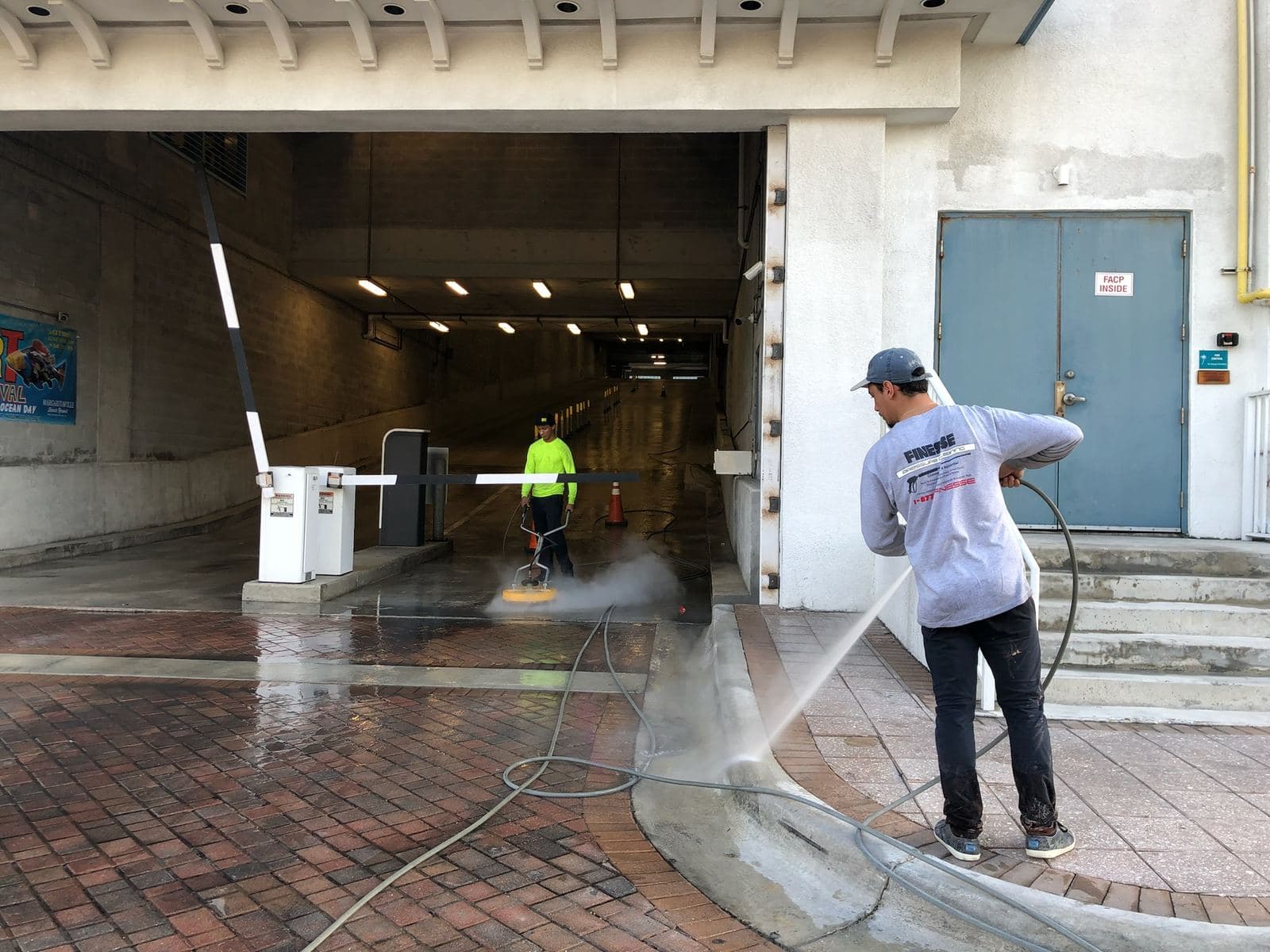 Crew pressure washing a storefront entrance walkway — Finesse Cleaning, South Florida