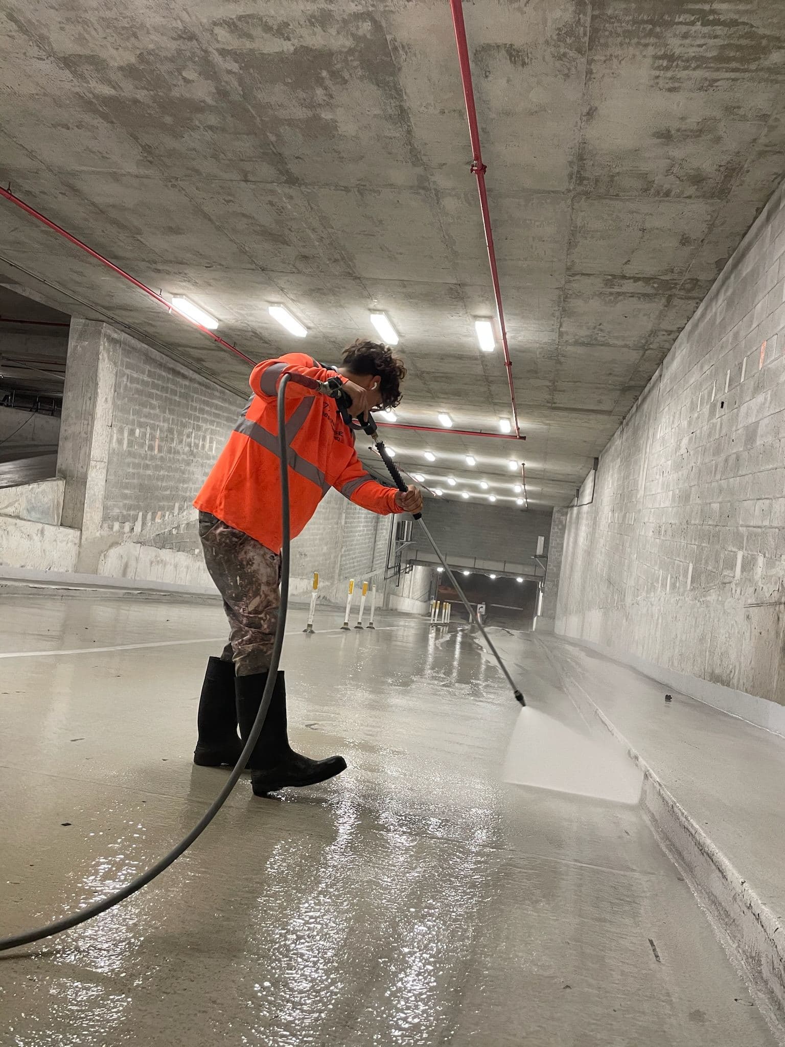 Crew pressure washing a parking garage floor — Finesse Cleaning, South Florida