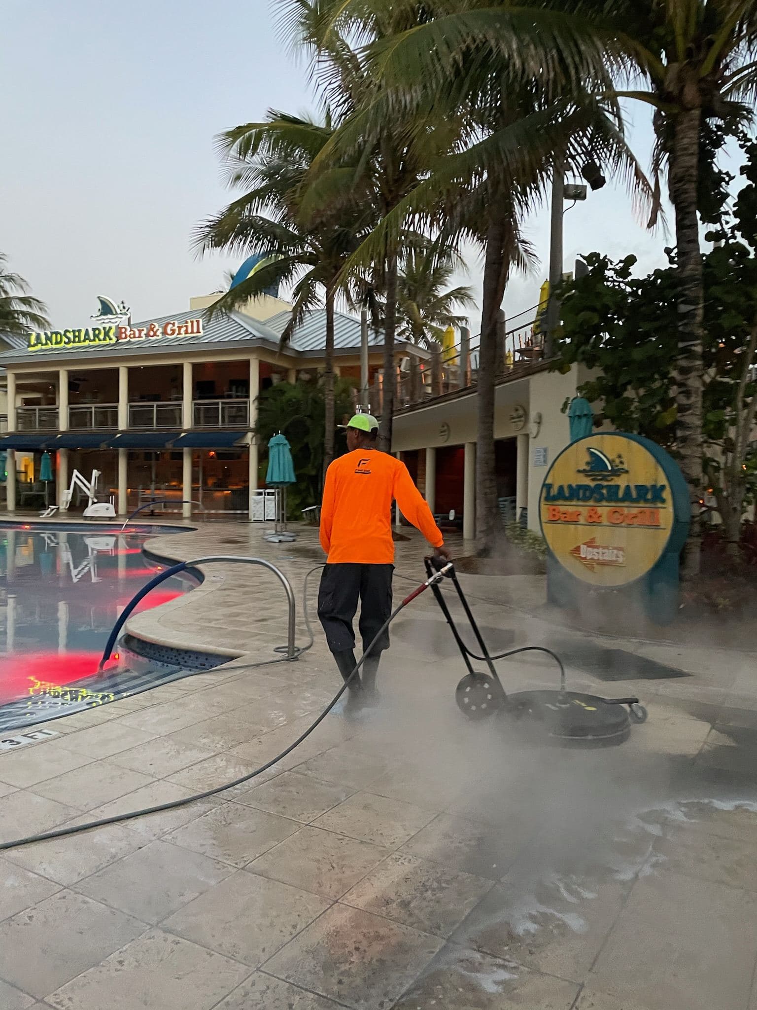 Crew pressure washing a walkway near a commercial building — Finesse Cleaning, South Florida