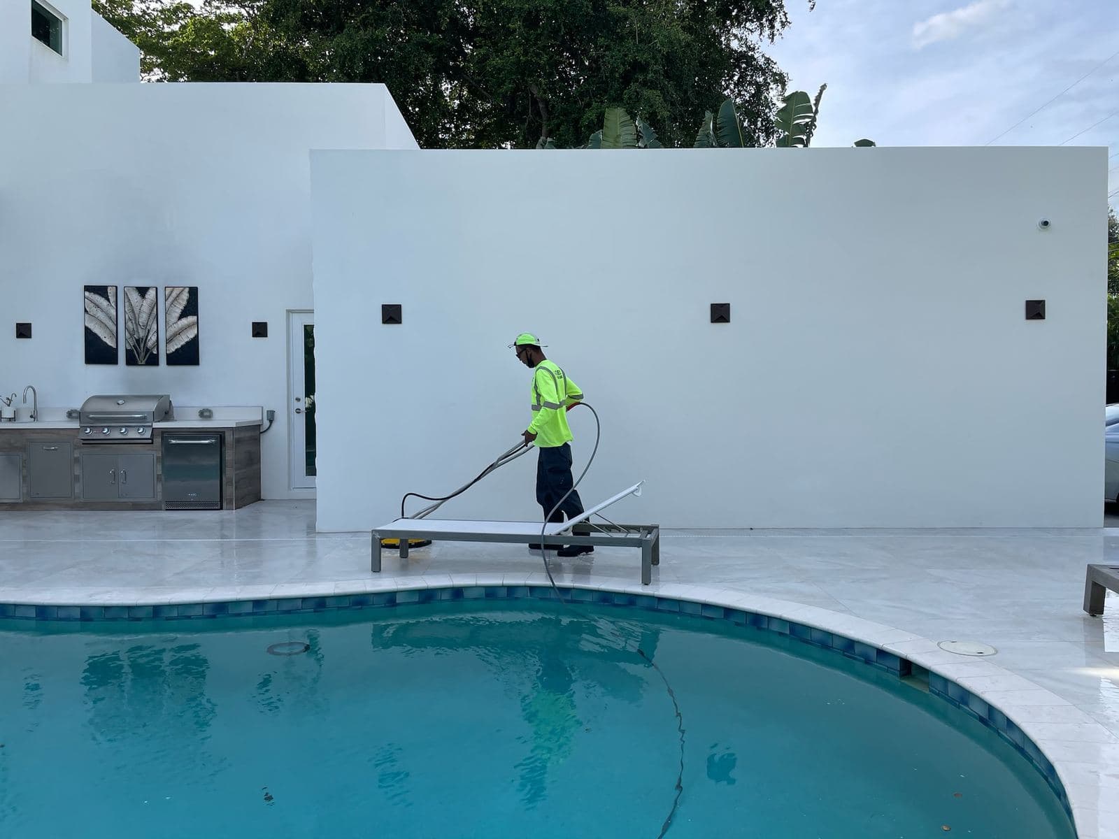 Crew washing an exterior wall next to a pool — Finesse Cleaning, South Florida