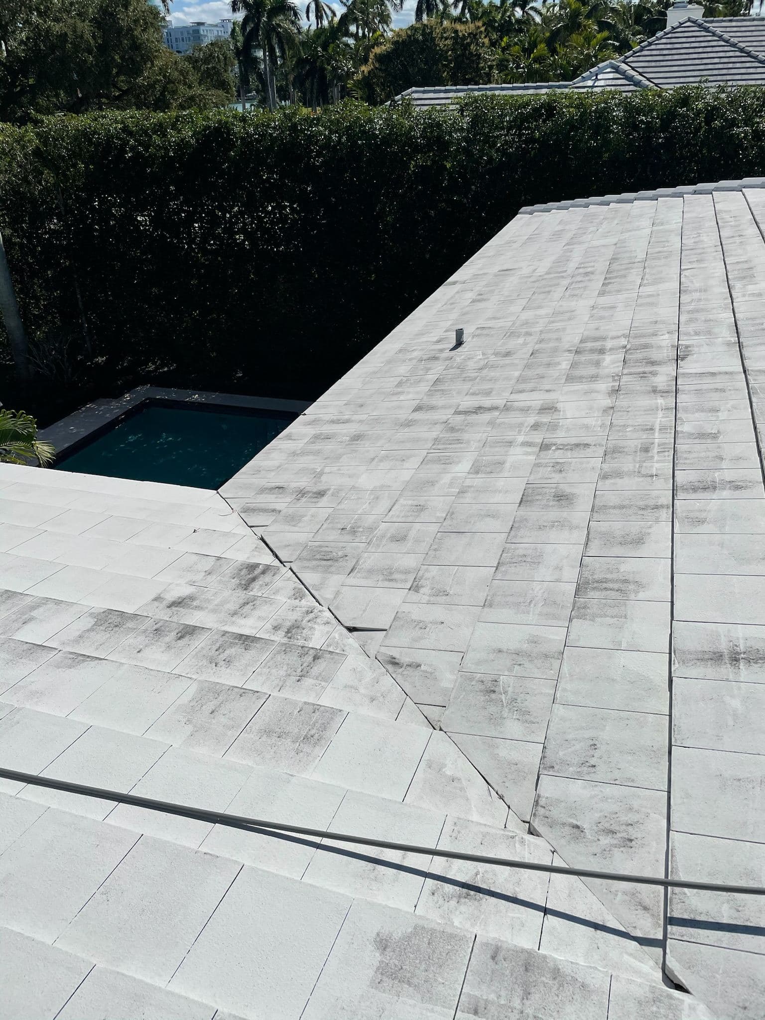 Flat coated roof after soft washing near a pool — Finesse Cleaning, South Florida