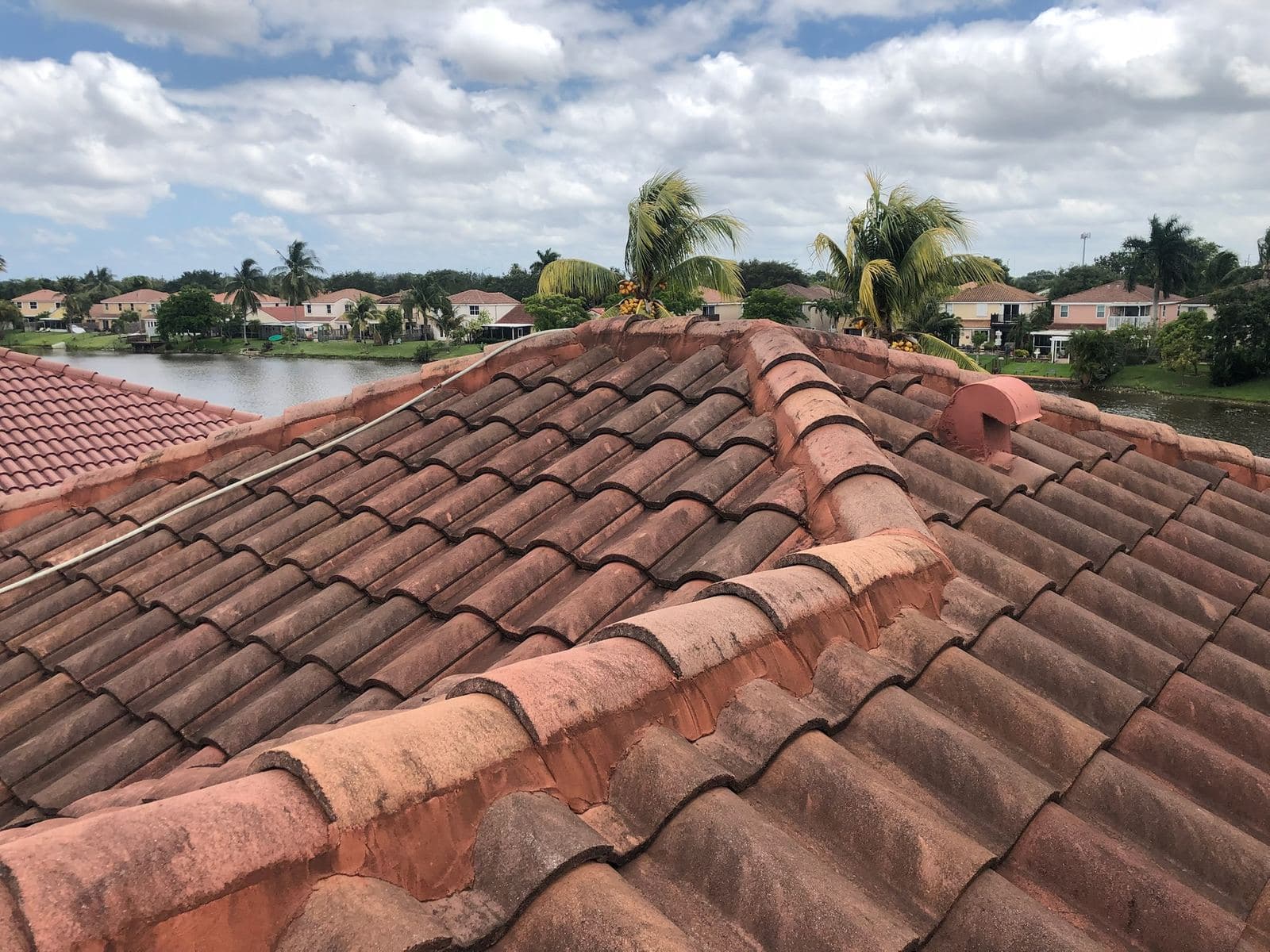 Clean terracotta tile roof after soft washing overlooking the water — Finesse Cleaning, South Florida