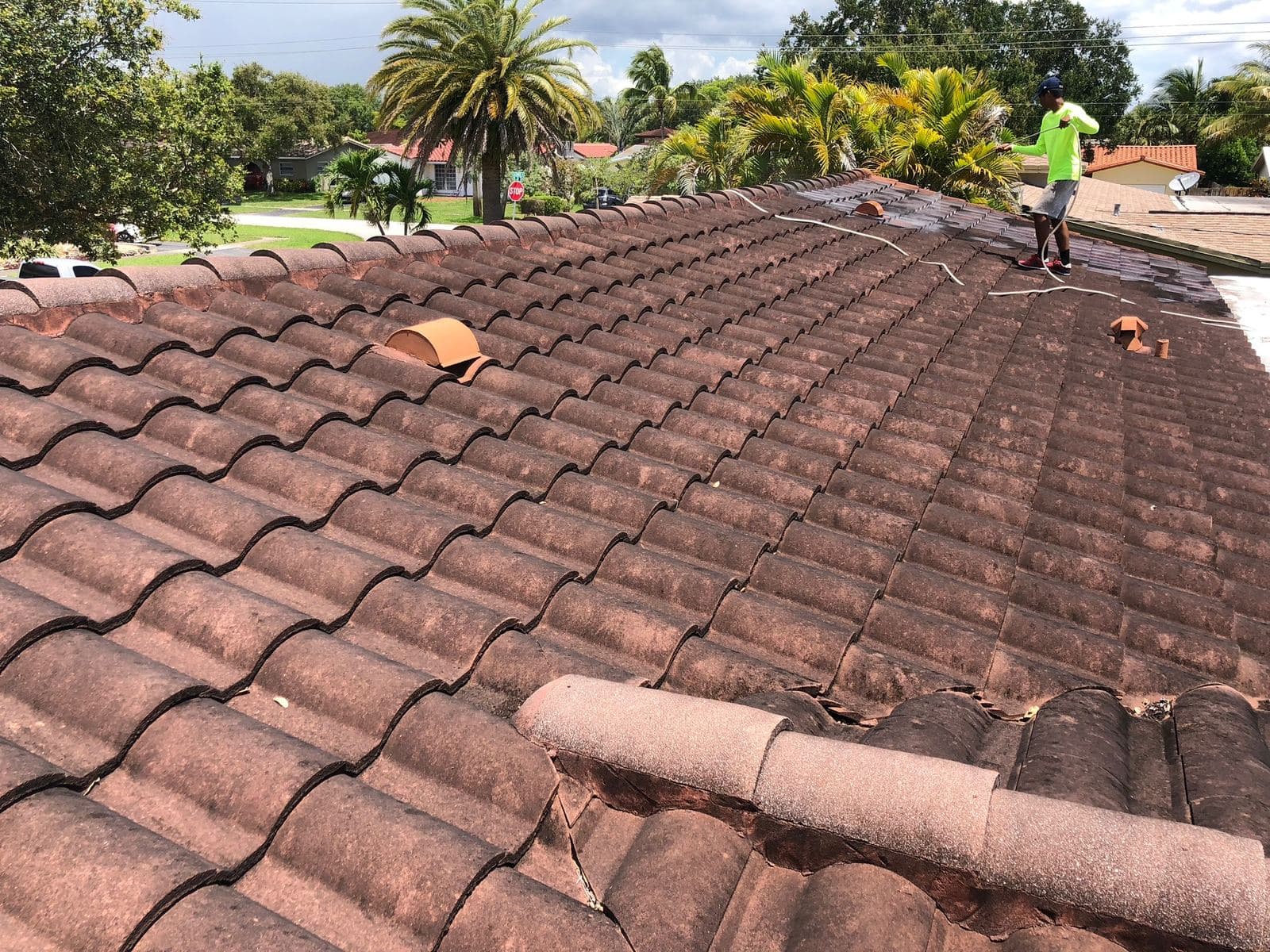 Aerial view of a crew soft washing a tile roof — Finesse Cleaning, South Florida