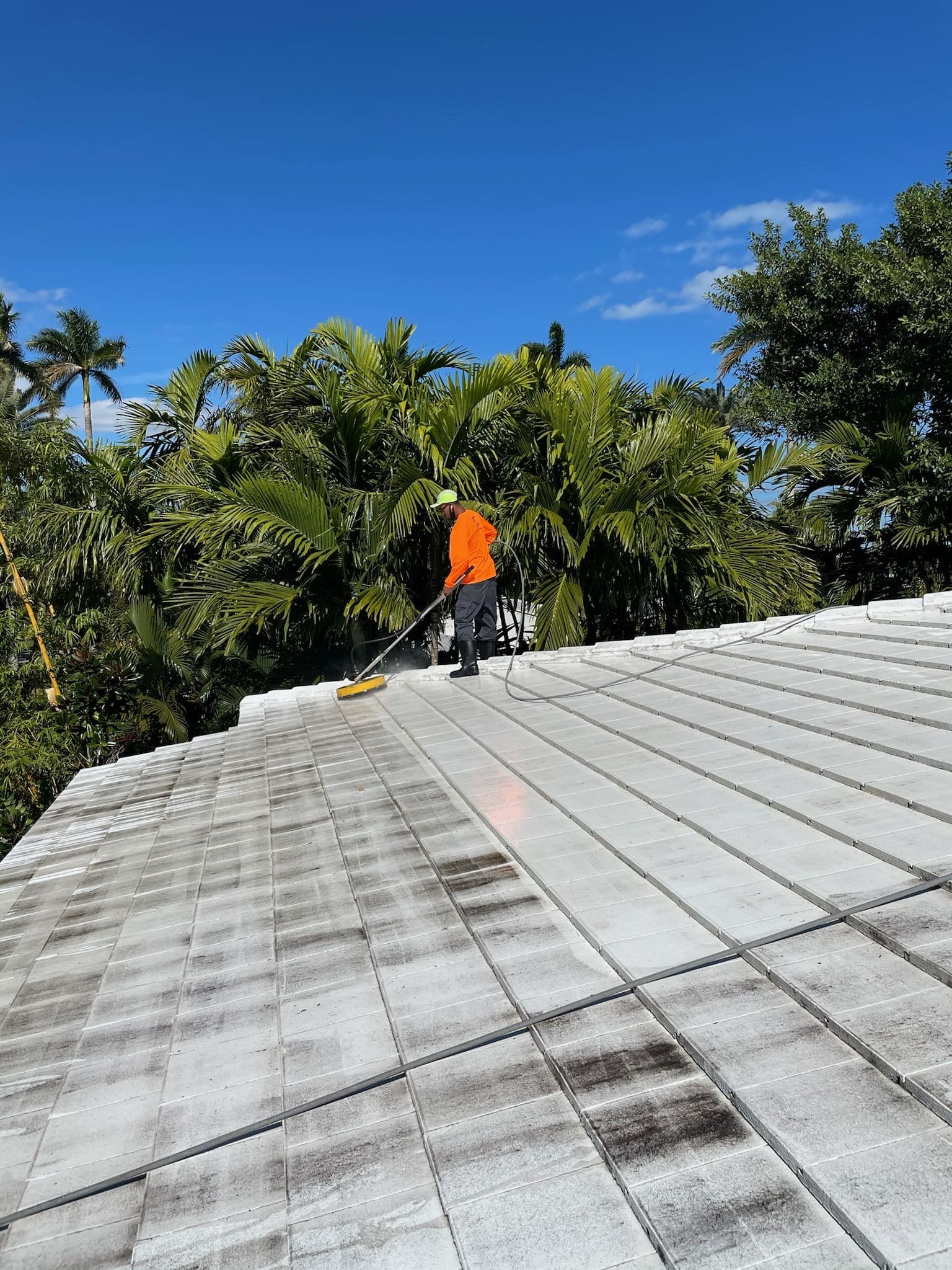 Crew walking a flat metal roof — Finesse Cleaning, South Florida